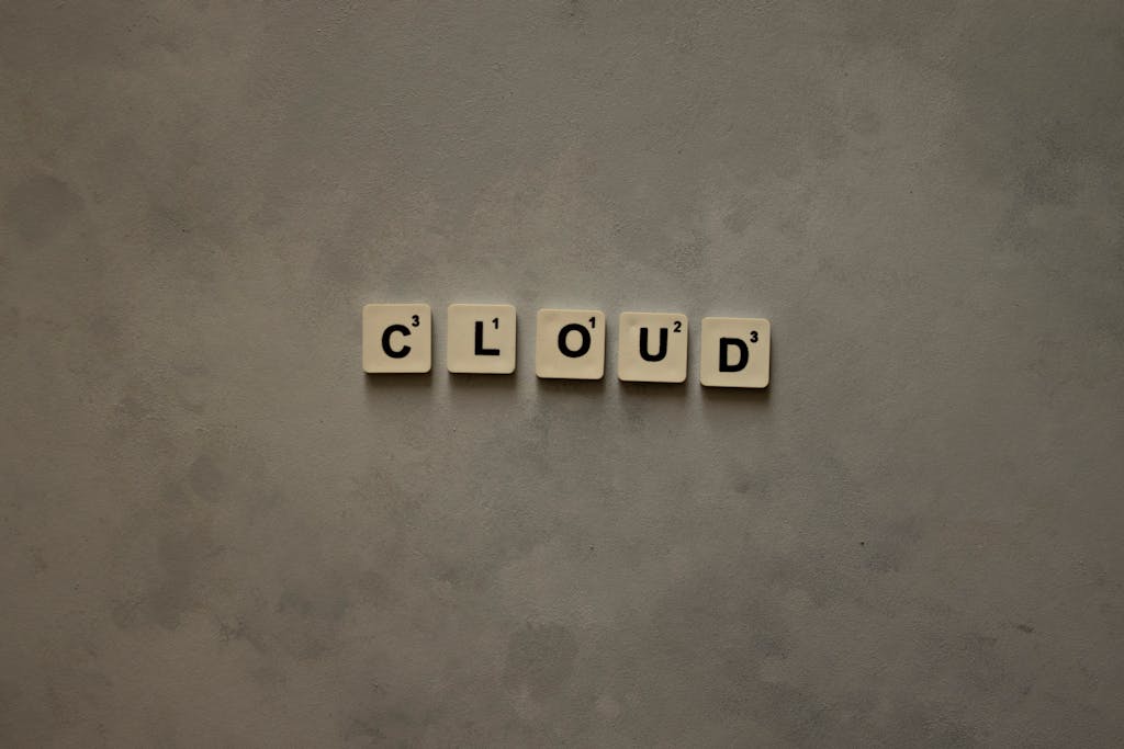 Scrabble tiles arranged to spell 'cloud' on a neutral textured backdrop, creative concept image.